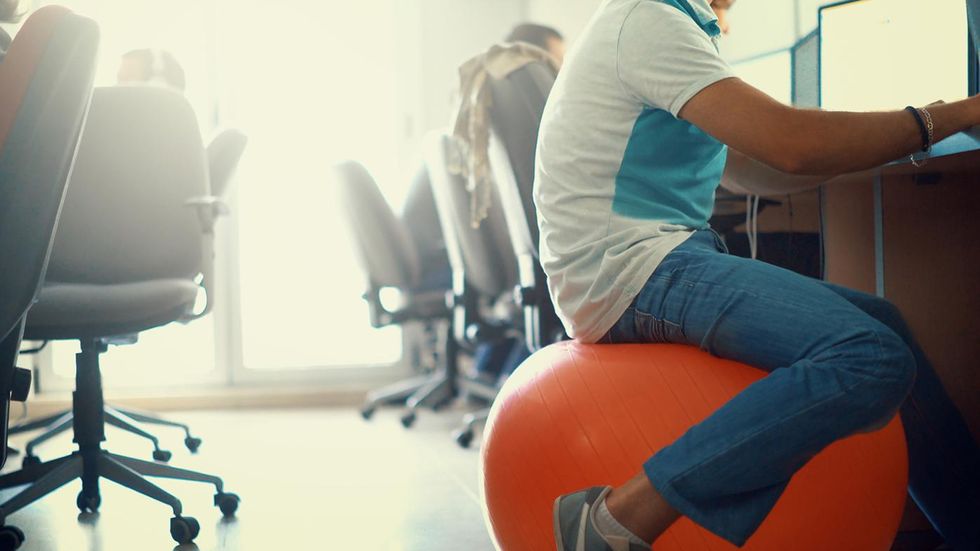 man sitting on yoga ball