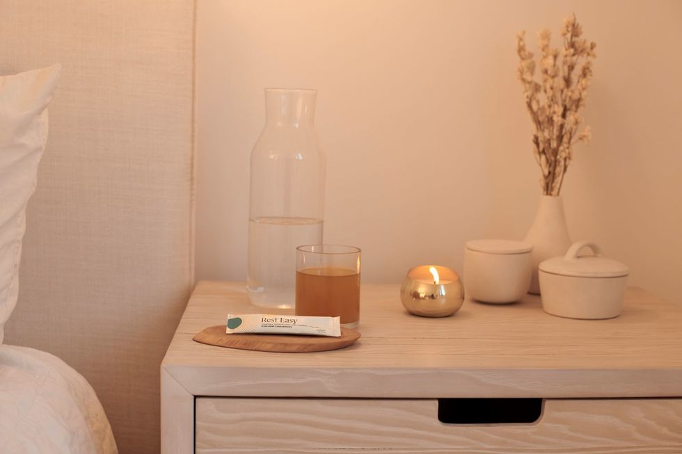 Candle lit on bedside table with Prima CBS sachet